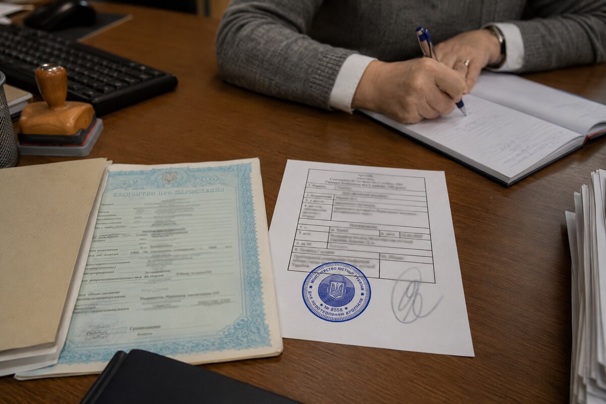 Справжній український апостиль поруч зі свідоцтвом про народження на робочому столі перекладачки